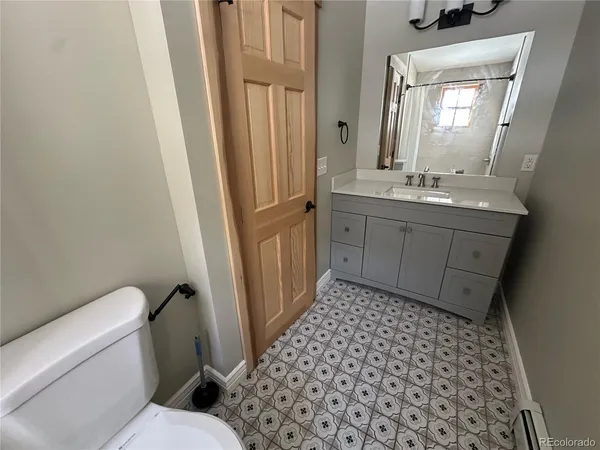 a bathroom with a sink a toilet a mirror and shower