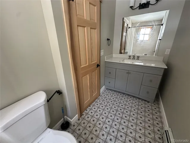 a bathroom with a sink a toilet a mirror and shower