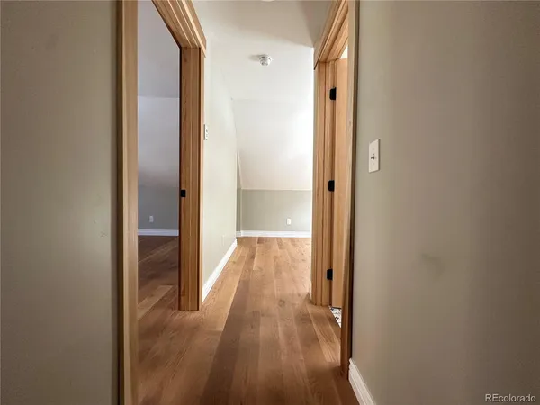a view of a hallway with wooden floor