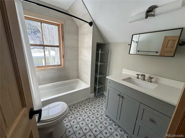 a bathroom with a granite countertop sink toilet and shower