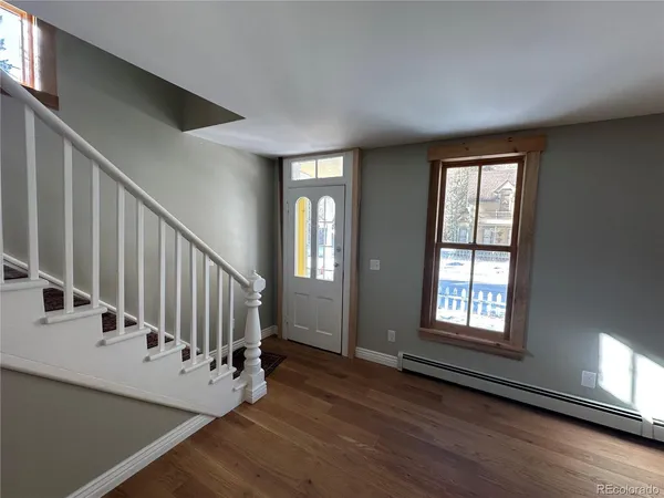 a view of an entryway with wooden floor and door