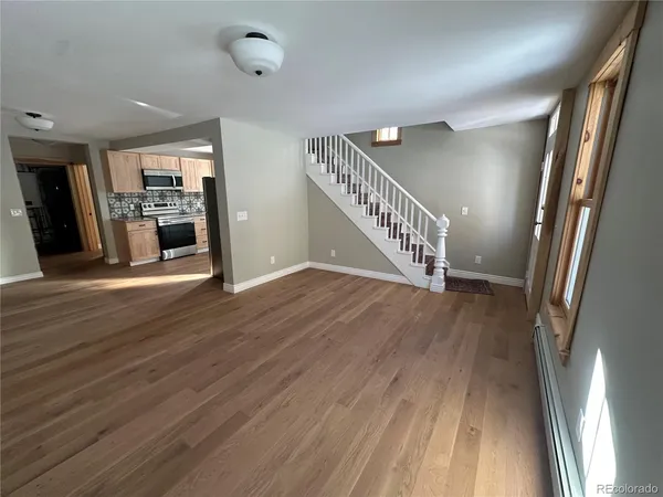 a view of a hallway with wooden floor and staircase