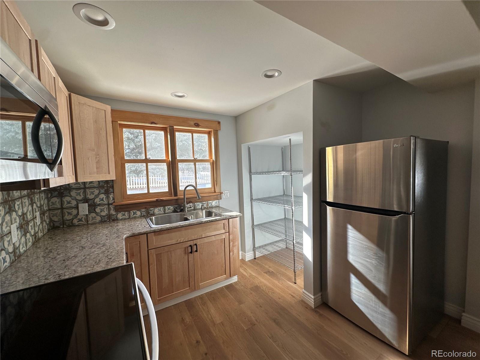 900 Rose Street Georgetown, CO 80444 - Photo 6 of 23 a kitchen with granite countertop a refrigerator a sink a stove and island