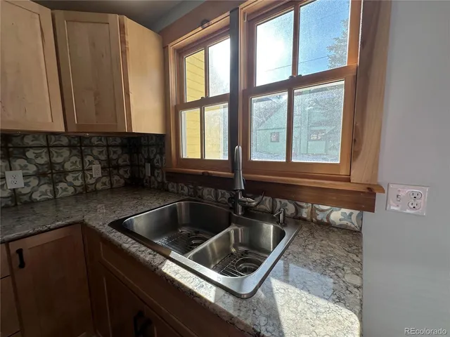 a kitchen sink with a stove and cabinets