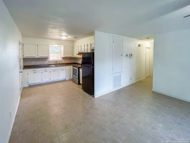 a view of a kitchen with refrigerator stove and a sink