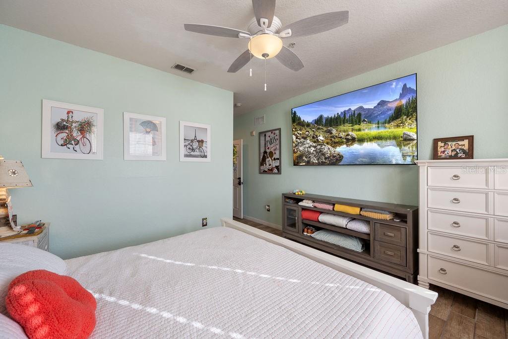 302 Terrace Ridge Circle, Unit 302 Davenport, FL 33896 - Photo 12 of 23 a bedroom with a bed and a flat screen tv