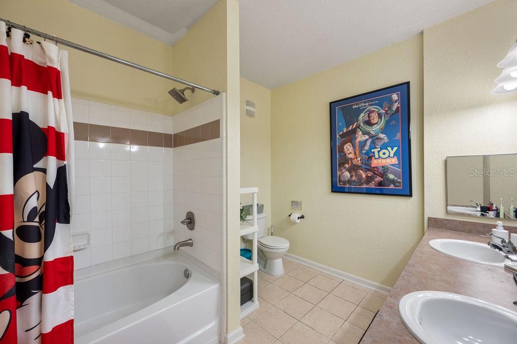 302 Terrace Ridge Circle, Unit 302 Davenport, FL 33896 - Photo 16 of 23 a bathroom with a bath tub a sink and a mirror