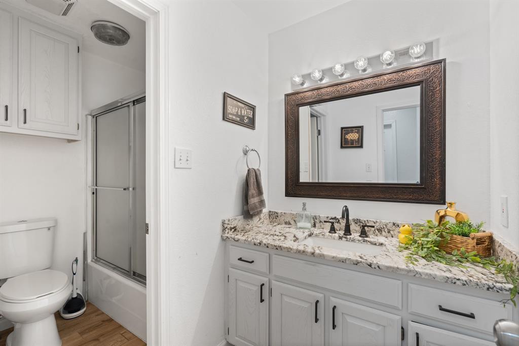 1013 Highland Road Cleburne, TX 76033 - Photo 16 of 33 a bathroom with a toilet sink and mirror