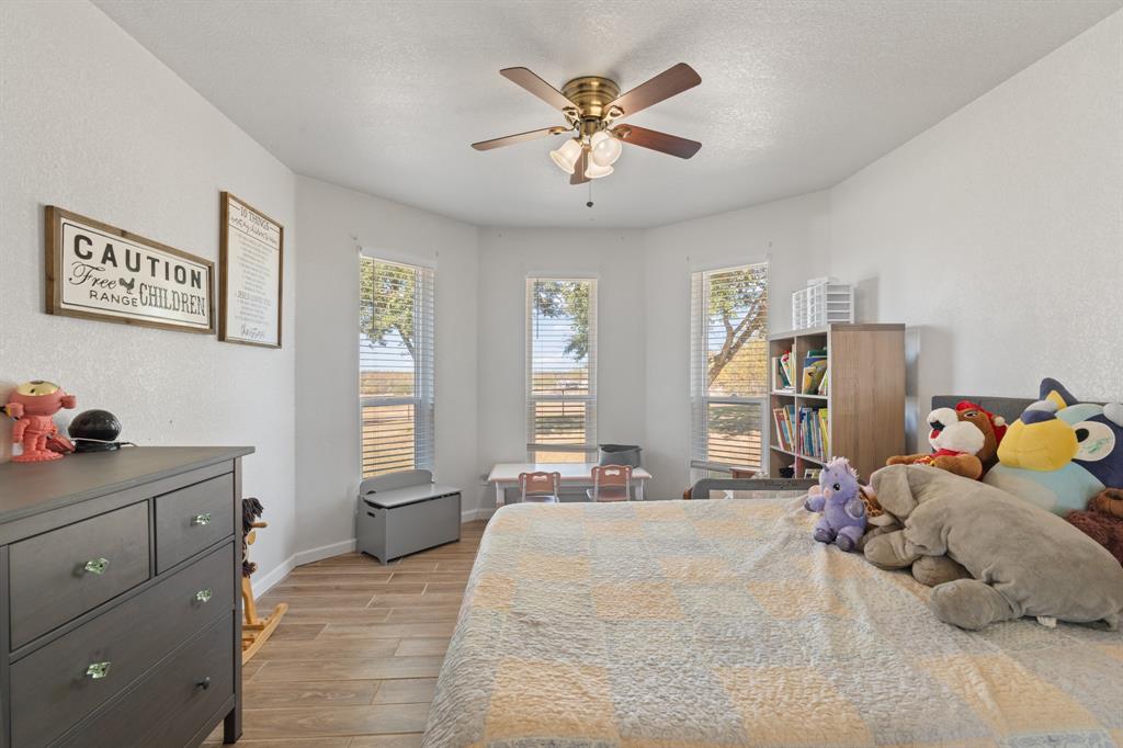 1013 Highland Road Cleburne, TX 76033 - Photo 18 of 33 a bedroom with a bed and a chandelier