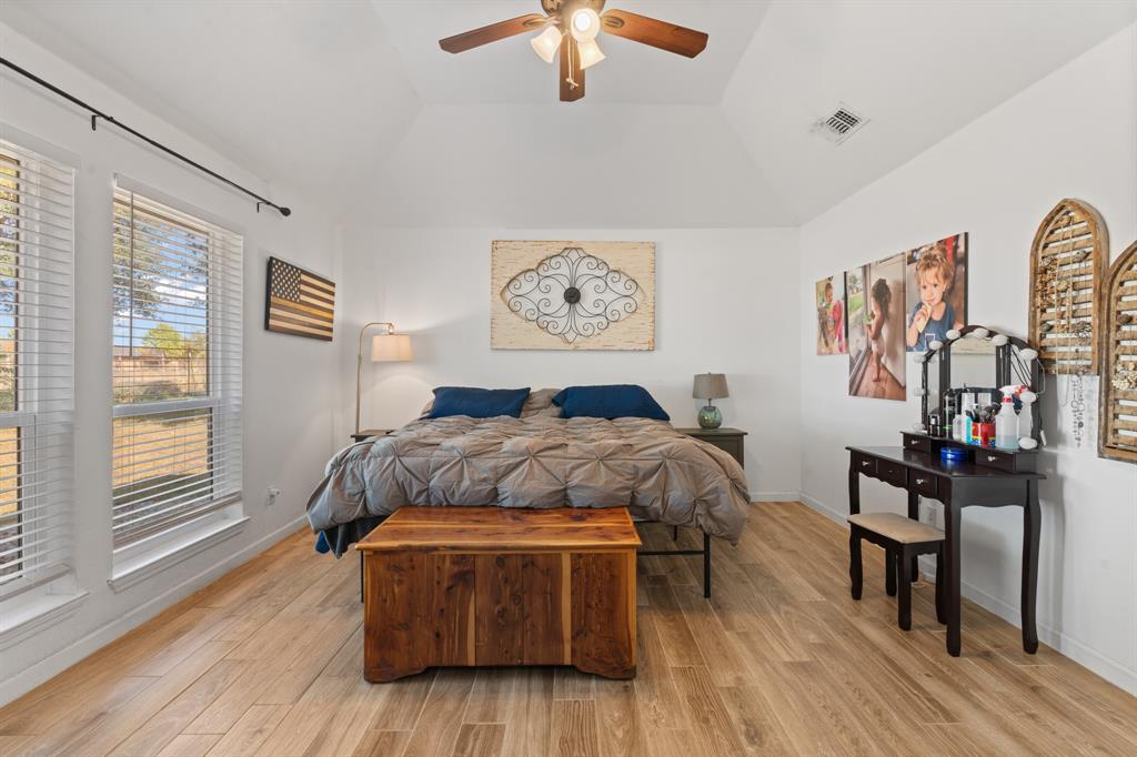 1013 Highland Road Cleburne, TX 76033 - Photo 21 of 33 a spacious bedroom with a bed and a chandelier