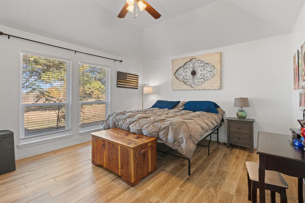 1013 Highland Road Cleburne, TX 76033 - Photo 22 of 33 a spacious bedroom with a bed and wooden floor
