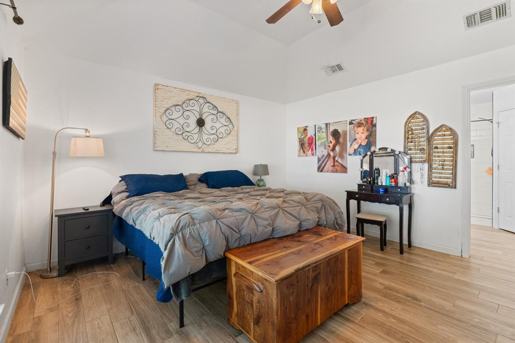 1013 Highland Road Cleburne, TX 76033 - Photo 23 of 33 a bedroom with a bed and a chandelier