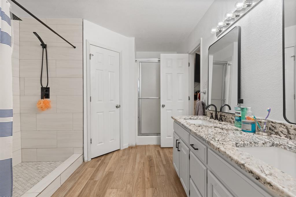 1013 Highland Road Cleburne, TX 76033 - Photo 27 of 33 a bathroom with a double vanity sink and mirror