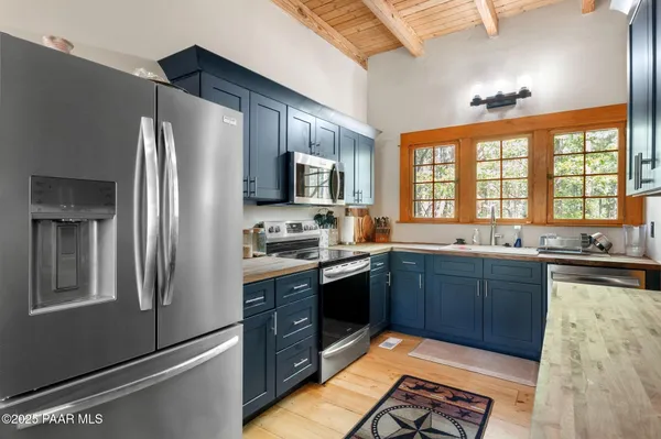 a kitchen with stainless steel appliances granite countertop a refrigerator stove top oven and sink