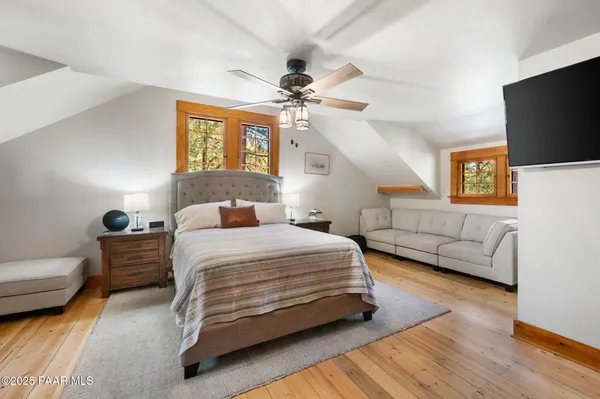a bedroom with a bed a couch and a flat screen tv