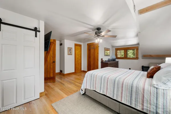 a bedroom with a large bed a chandelier and closet