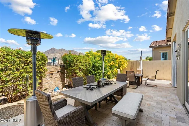 a living room with patio furniture and a potted plant