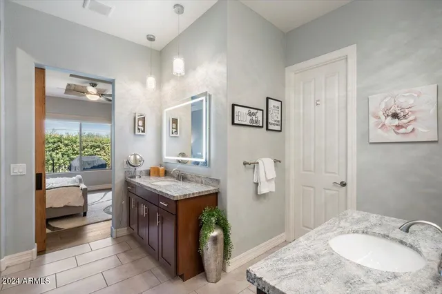 a bathroom with a granite countertop sink a toilet and mirror