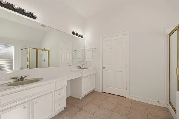 a spacious bathroom with a granite countertop sink a mirror and a shower