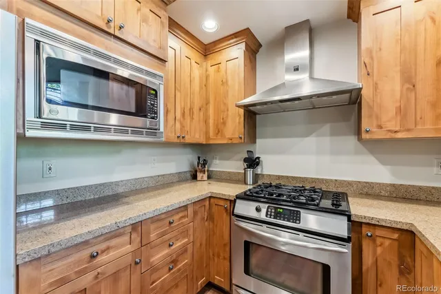a kitchen with stainless steel appliances granite countertop a stove and a microwave