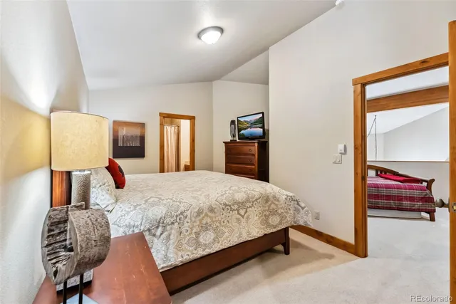 a bedroom with a bed and dresser with mirror