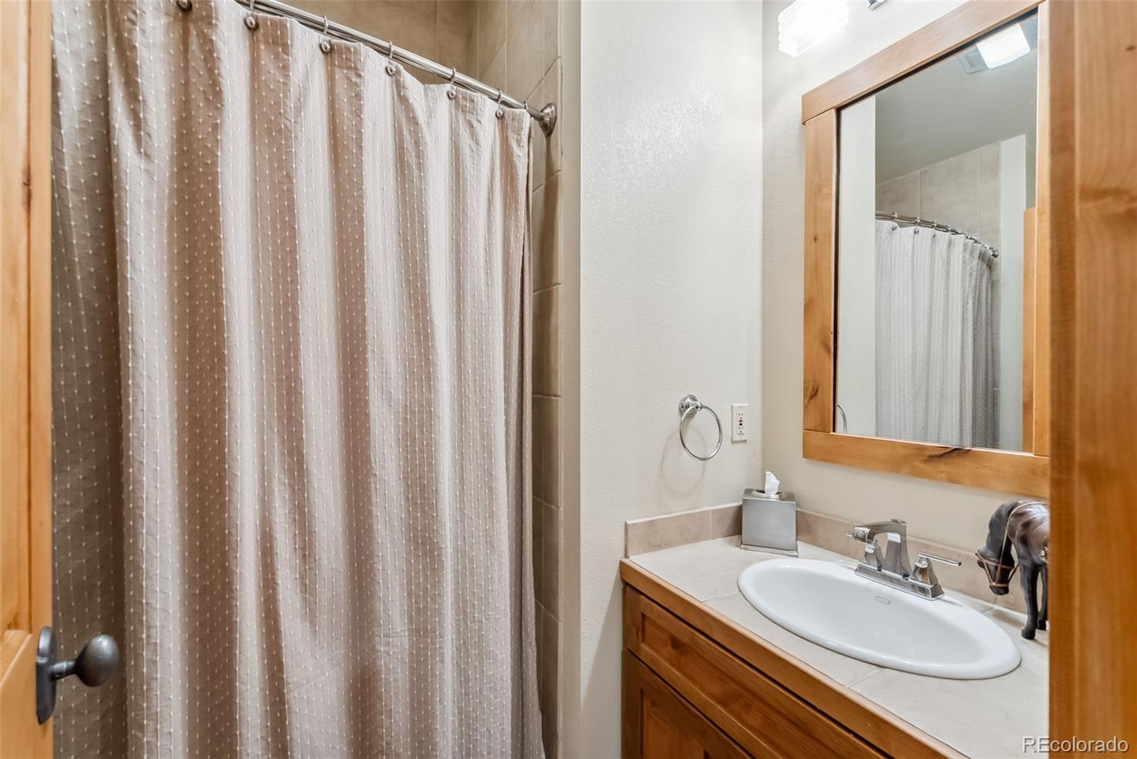 0024 Rasor Drive Dillon, CO 80435 - Photo 27 of 37 a bathroom with a granite countertop sink and a mirror