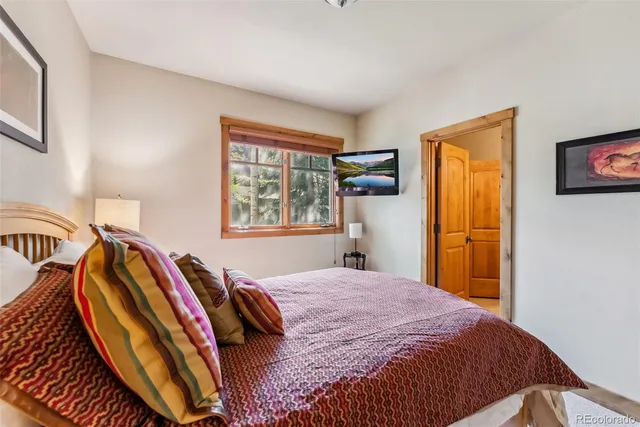 a large bedroom with a bed and wooden floor