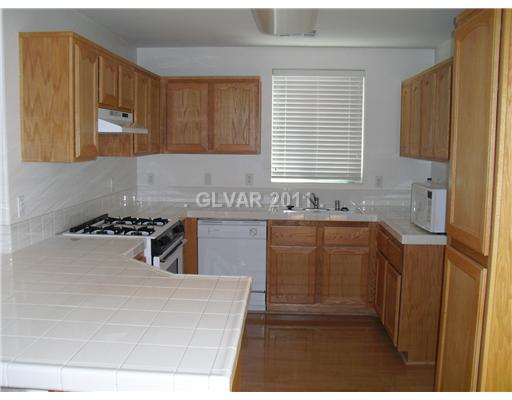 7191 Dicentra Road Las Vegas, NV 89113 - Photo 3 of 14 Kitchen. Spacious kitchen with tile counters and bright wood flooring!