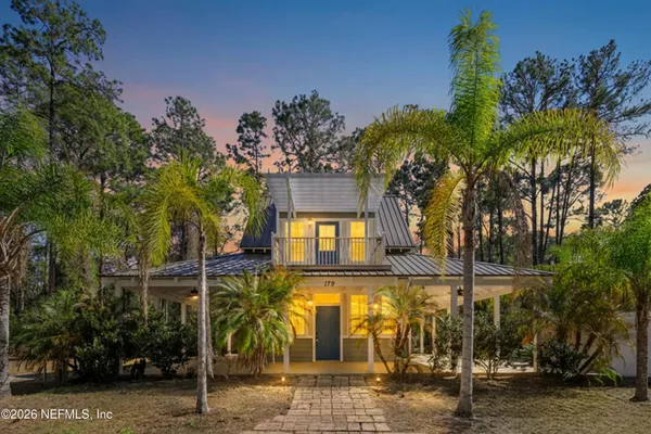 a front view of a house with a tree