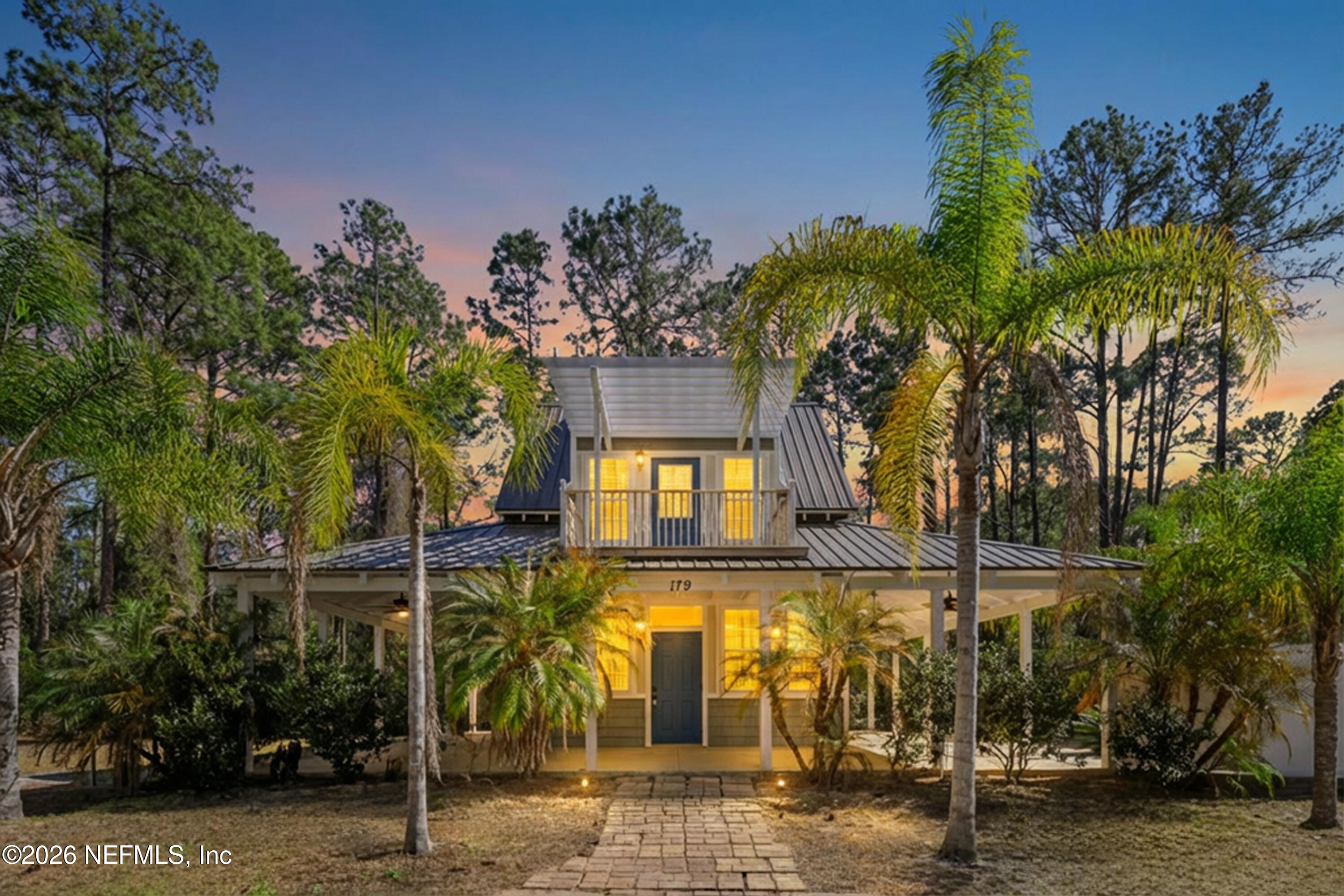 a front view of a house with a tree