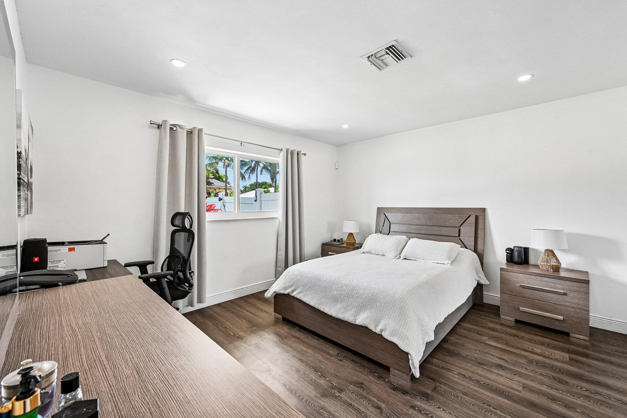 2940 Northeast 39th Court Lighthouse Point, FL 33064 - Photo 24 of 42 a bedroom with a bed and wooden floor