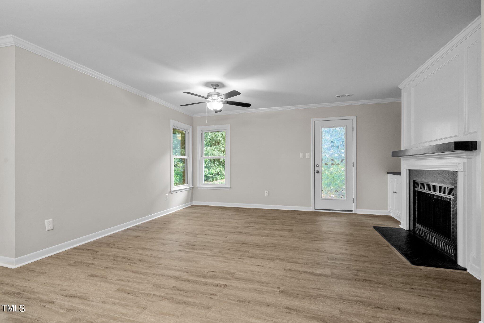 3408 Comstock Road Raleigh, NC 27604 - Photo 12 of 33 a view of an empty room with a fireplace and a window