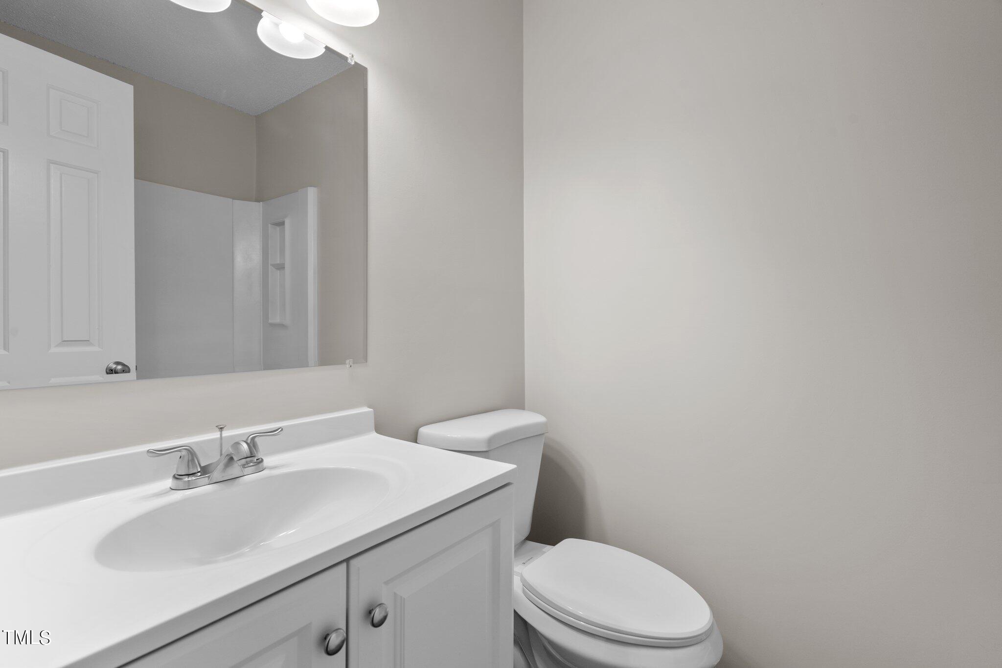 3408 Comstock Road Raleigh, NC 27604 - Photo 17 of 33 a bathroom with a sink a toilet and mirror
