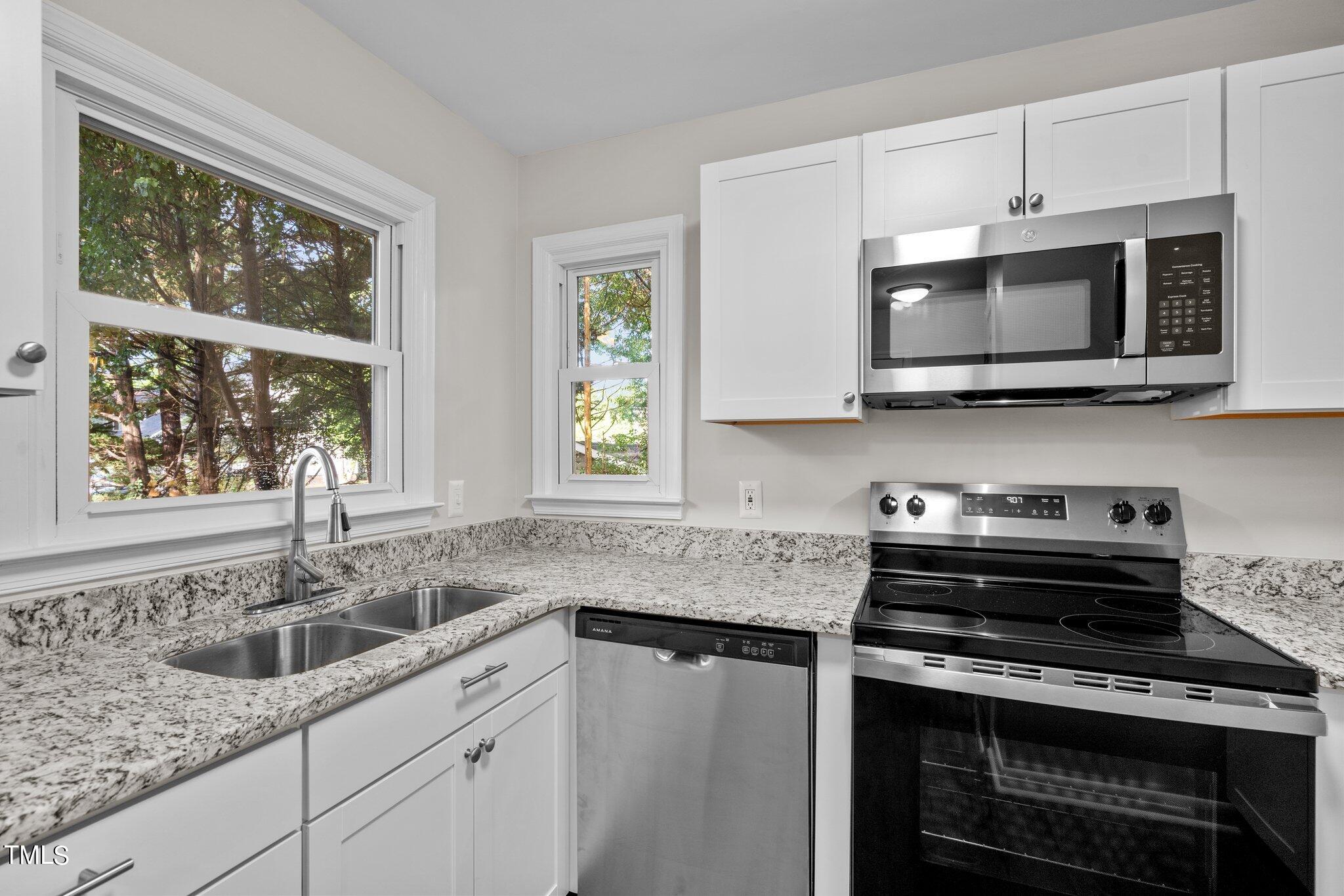 3408 Comstock Road Raleigh, NC 27604 - Photo 3 of 33 a kitchen with stainless steel appliances granite countertop a sink stove and microwave