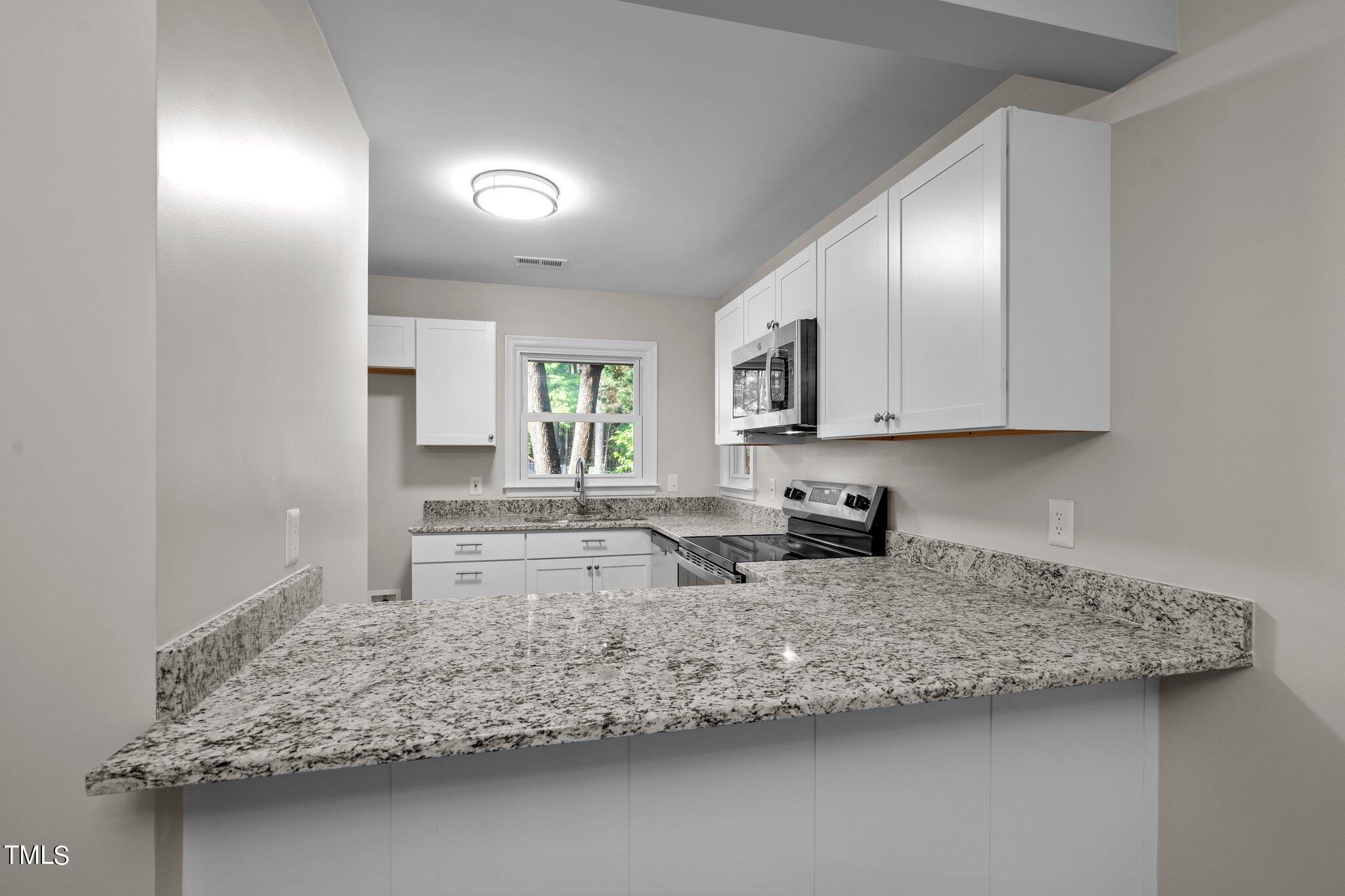 3408 Comstock Road Raleigh, NC 27604 - Photo 8 of 33 a kitchen with stainless steel appliances granite countertop a sink stove and cabinets