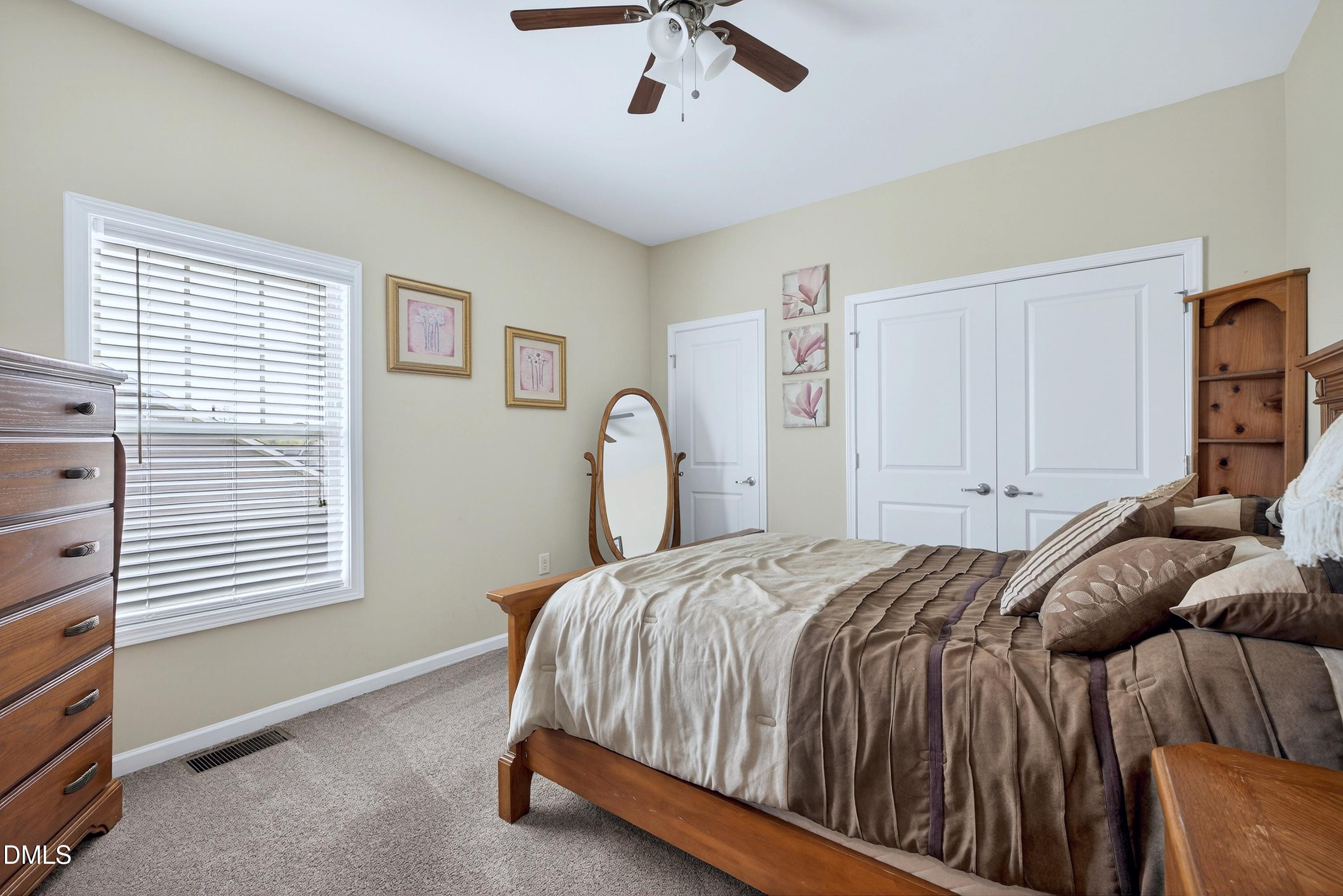2025 Great Ridge Parkway Chapel Hill, NC 27516 - Photo 32 of 61 a bedroom with a bed and a chandelier