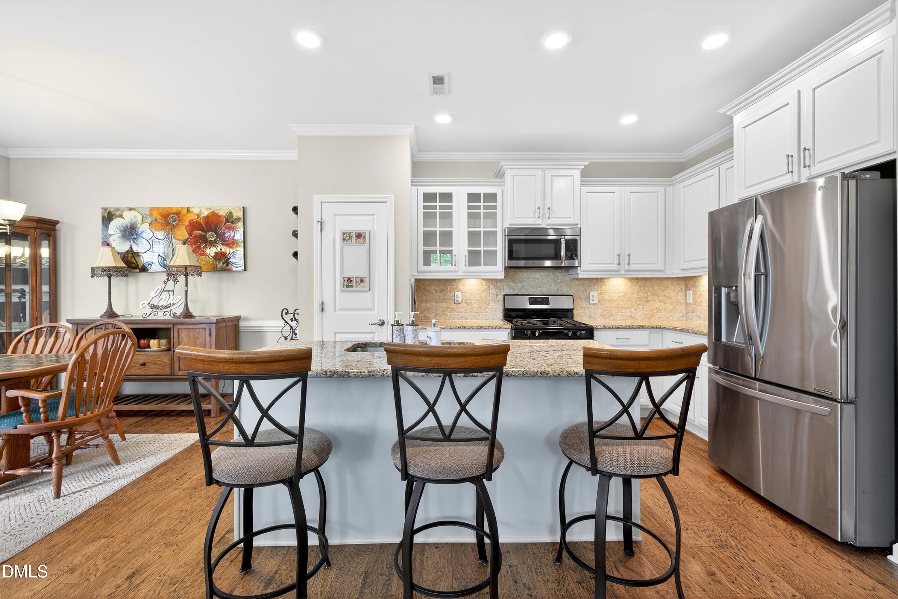 2025 Great Ridge Parkway Chapel Hill, NC 27516 - Photo 6 of 61 a kitchen with stainless steel appliances granite countertop a dining table chairs refrigerator and sink