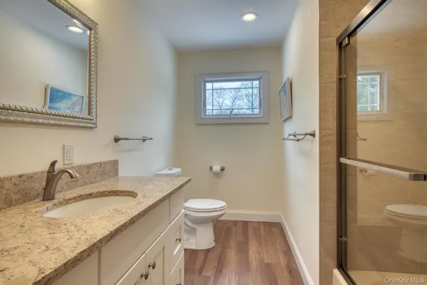 a bathroom with a granite countertop sink toilet and shower
