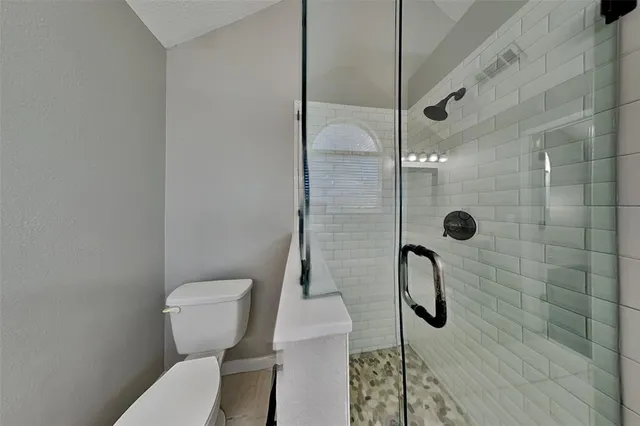 a white toilet sitting next to a bathroom shower