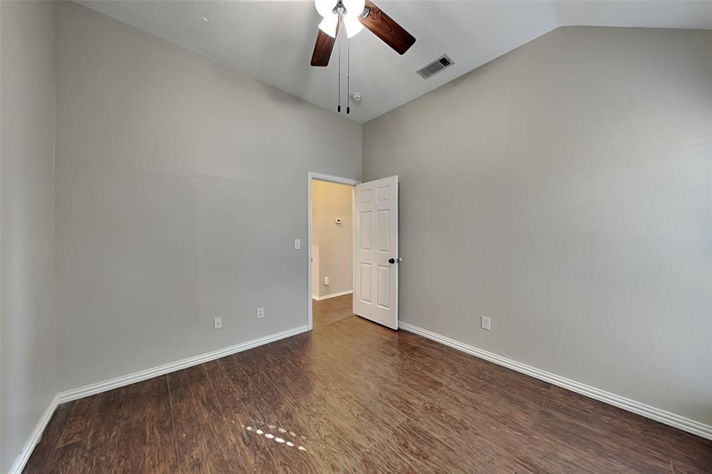 7641 Lancelot Road Frisco, TX 75035 - Photo 13 of 21 an empty room with a ceiling fan and wooden floor