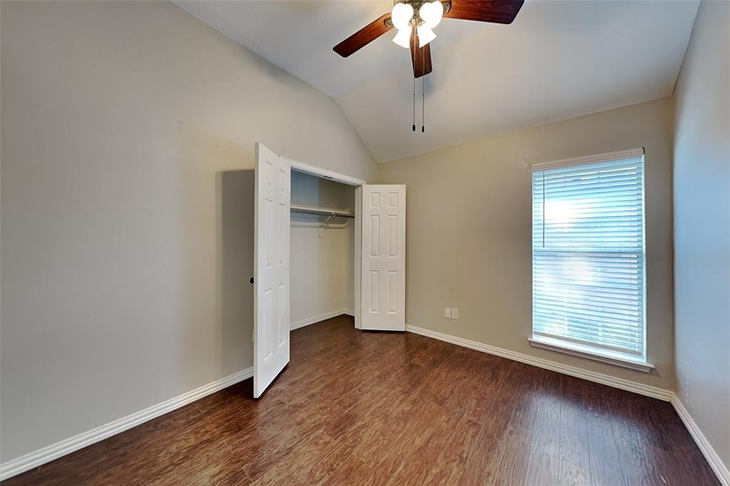 7641 Lancelot Road Frisco, TX 75035 - Photo 15 of 21 an empty room with wooden floor chandelier fan and windows
