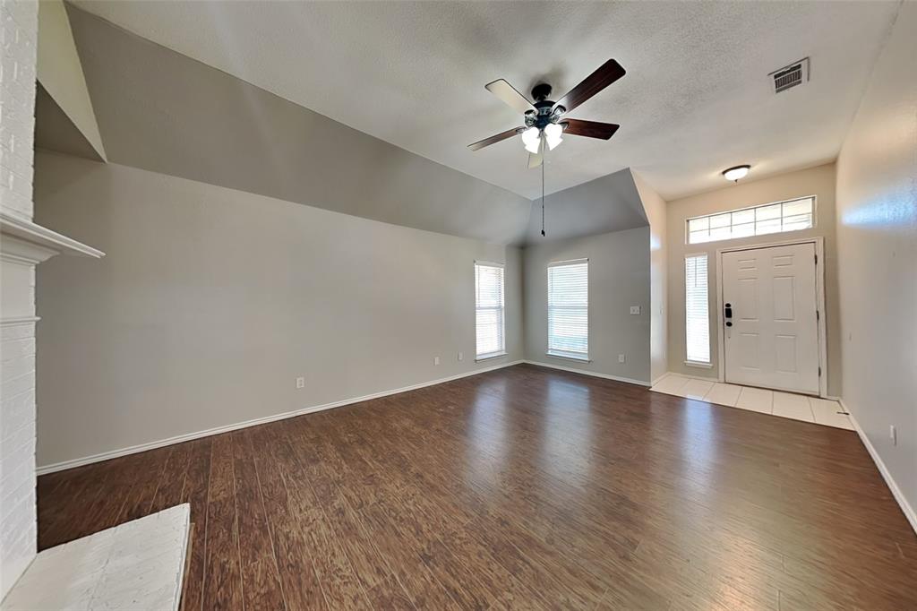 7641 Lancelot Road Frisco, TX 75035 - Photo 2 of 21 a view of an empty room with wooden floor and a ceiling fan