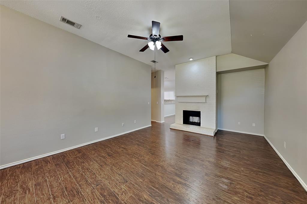 7641 Lancelot Road Frisco, TX 75035 - Photo 3 of 21 a view of an empty room with wooden floor a fireplace and a window