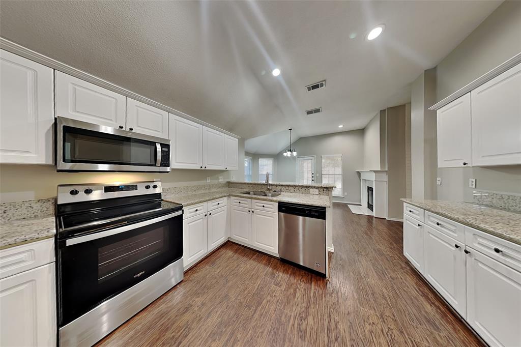 7641 Lancelot Road Frisco, TX 75035 - Photo 5 of 21 a large kitchen with cabinets wooden floor and stainless steel appliances
