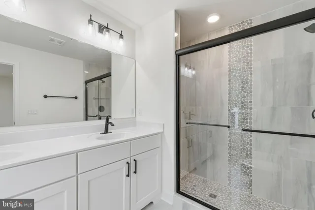 a bathroom with a shower sink and mirror