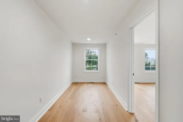 a view of a big room with wooden floor and windows