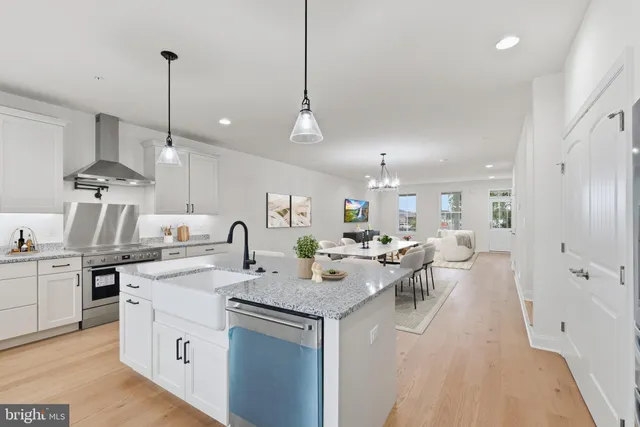 a large kitchen with kitchen island a white counter space a sink appliances and a cabinets