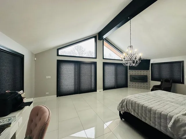 a spacious bedroom with a bed and a chandelier