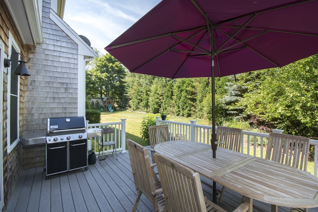 123 Tilden Road Scituate, MA 02066 - Photo 25 of 27 a view of a patio with table and chairs under an umbrella