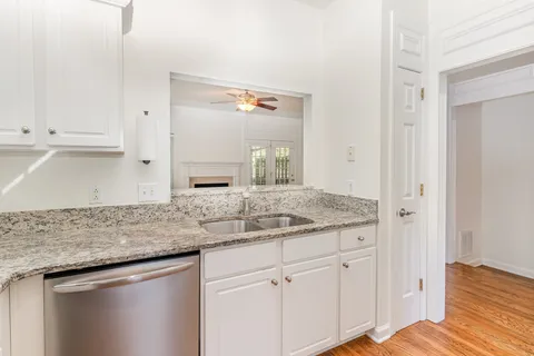 a kitchen with granite countertop white cabinets and a sink